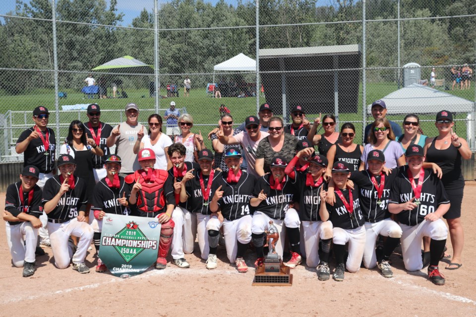 The Prince George Bantam AA Knights are joined by their parents on the field after claiming the 2019 B.C. Minor Baseball Championship (via Kyle Balzer)