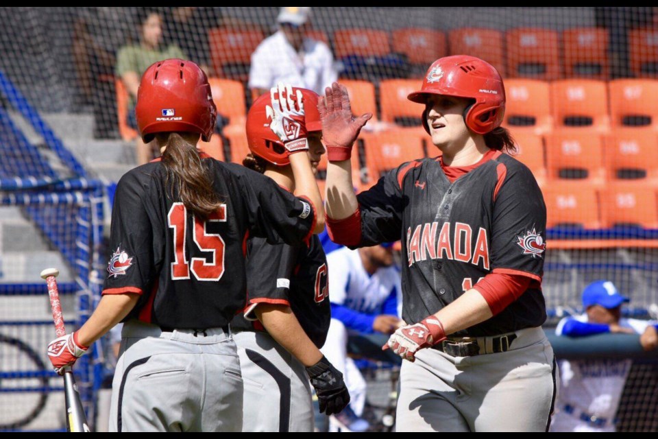 Amanda Asay (#19) high-fives her Canadian teammates in a game at the 2019 Pan-Am Women's Baseball Championships (via World Baseball-Softball Confederation)