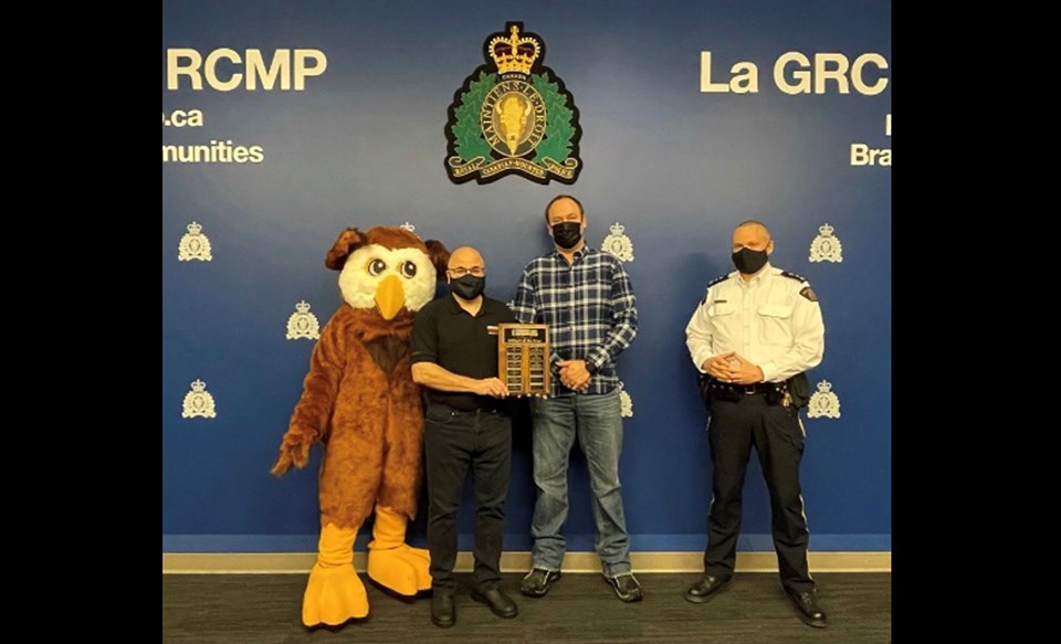 Prince George RCMP Cst. Ryan Underhill (2nd right) accepts the 2020 Officer of the Year from Northern B.C. Crime Stoppers.