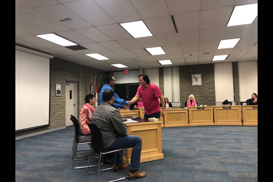 Trustee Trent Derrick shakes hand with Lheidli Elders Clifford Quaw and Kenora Stewart as they and Dayi Pountney as they speak with the board. (via Hanna Petersen)