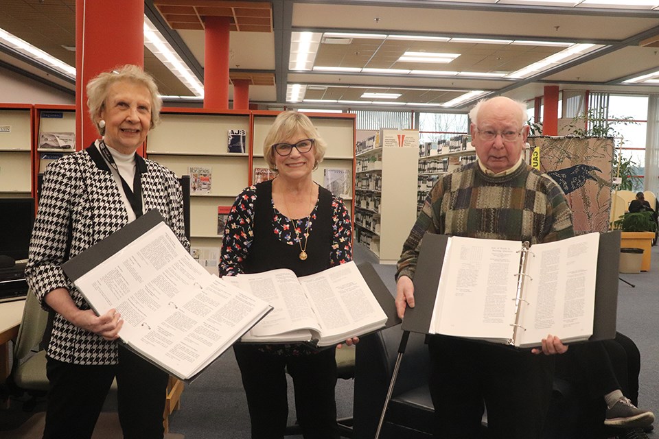 Current chair of the Archival Newspaper Educational Articles Project Tiiu Noukas (left) and former chair Bob Wall (right) present CNC Resource Centres Director Kathy Plett with a three volume collection of news articles detailing local public school education from 1910 to 1946. (via Hanna Petersen)