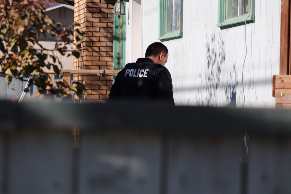 A Prince George RCMP officer searches for evidence at a home in the area of Norwood Street and Strathcona Avenue. (via Jessica Fedigan)