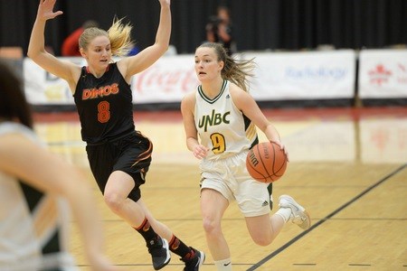 Emily Holmes (#9) dribbles up-court against the Calgary Dinos in a Canada West playoff game. (via UNBC Athletics)
