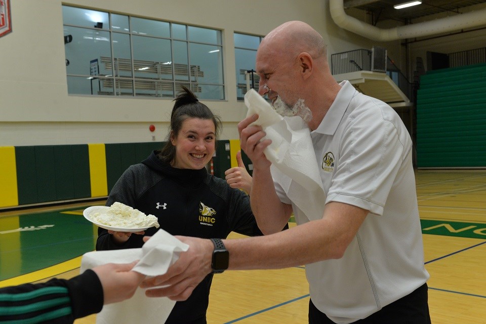 UNBC women's basketball head coach Sergey Shchepotkin takes a pie to the face after his team fundraised a new school record from the 2021 virtual Shoot for the Cure.