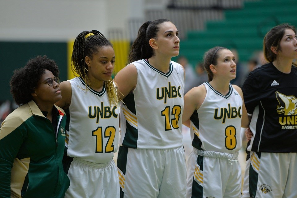 Vasiliki Louka (middle) stands with her UNBC women's basketball teammates. She's now been inducted to the Timberwolves Wall of Honour. 