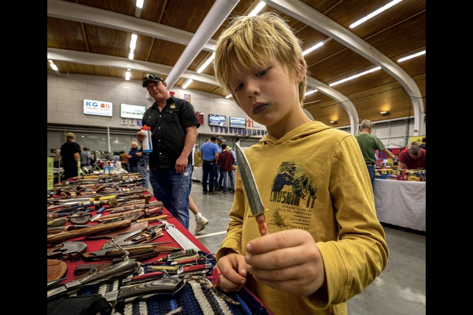 Kai Simpson, 7, examines a small hunting knife he found on a dealers table while attending the PG rod and Gun Club's Gun and Sportsman Show in Kin 1 Sunday, June 1, 2025.