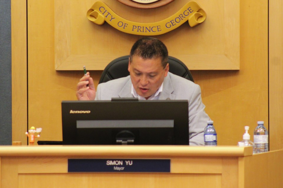 Mayor Simon Yu raises his hand to indicate a vote to move forward a rezoning application for a proposed RV dealership on Giscome Road at the Monday, July 28, 2025 Prince George city council meeting.