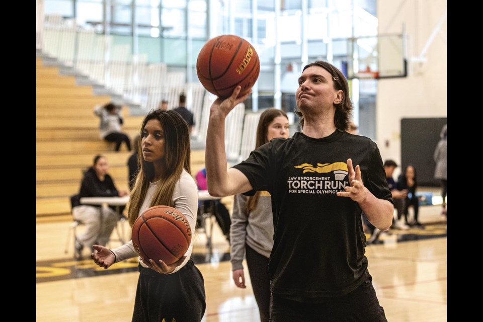 Special Olympics athlete Chase Caron takes his turn at the free throw line as volunteer Naiha Manhas feeds him his next shot during the Rotary Hoop-A-Thon at Duchess Park Secondary School Saturday, April 5, 2025. 