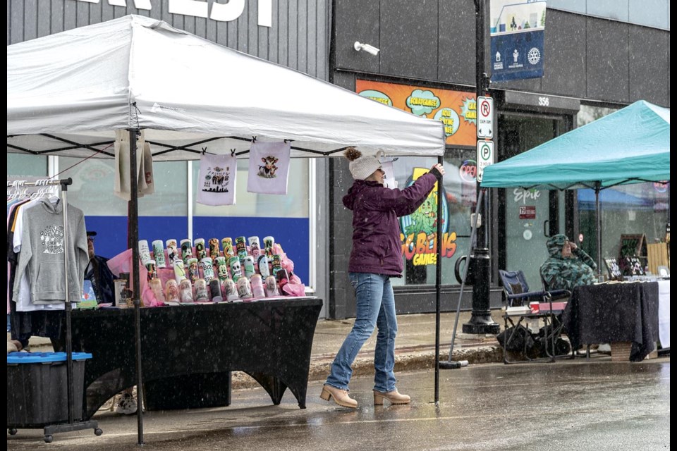 Marla Jarvie of the Hidden Kee pulls the canopy over her stall tight to prevent the rain from pooling on top during the 2nd Annual 420 Block Party held in the 300 block of George Street with local vendors and food trucks celebrating cannabis culture in a family friendly setting Sunday, April 20, 2025.