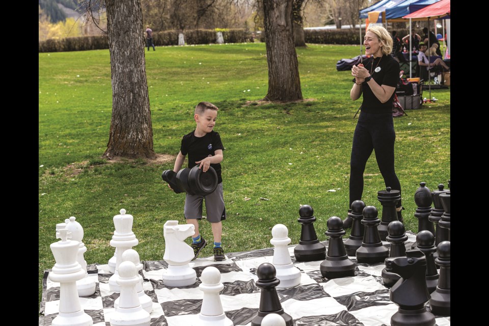 PG Public Library library assistant Ashley Neff cheers on Ronin Latta, 7, after he found an unexpected way to take her knight in a game of outdoor chess during the Active Living Market in the Park on Saturday, May 4, 2024 at Lheidli T'enneh Memorial Park in Prince George, B.C. A variety of activities, programs and events allowed the public to identify and connect with various groups.