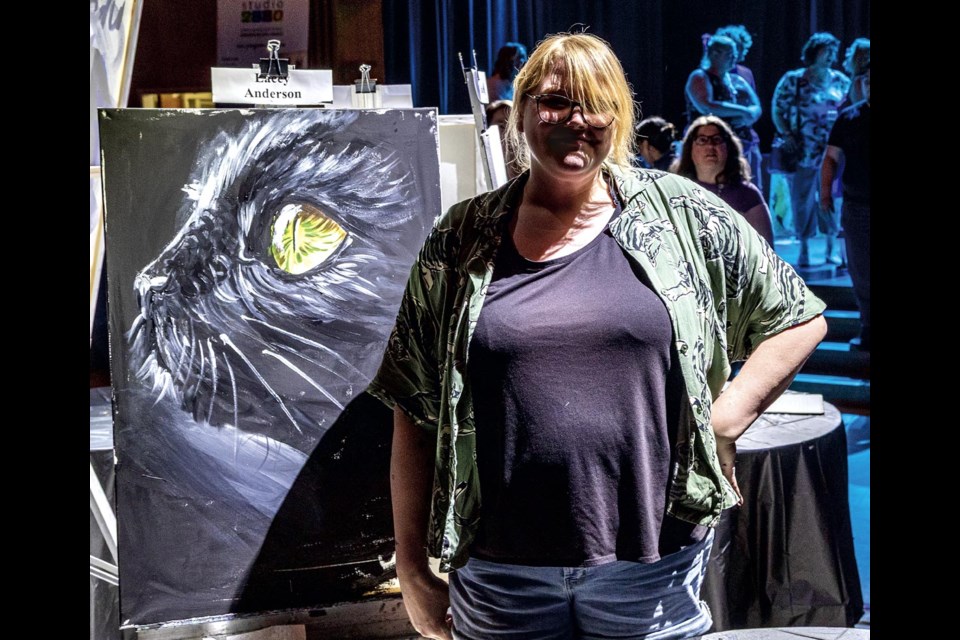 Darcy Anderson, posing with her competition winning painting, after the final round of the Prince George and District Community Arts Council Art Battle at Knox Performance Centre Friday, May 2, 2025.