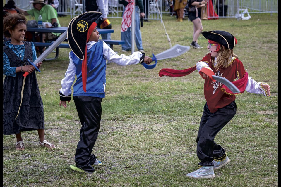 Amalid Chewitt, 7, has a mock pirate battle with Lilly Gallant, 9, while his twin sister Kahmanda waits for a chance to jump in during the BCNE Renaissance Faire at the exhibition grounds Saturday, July 26, 2025.