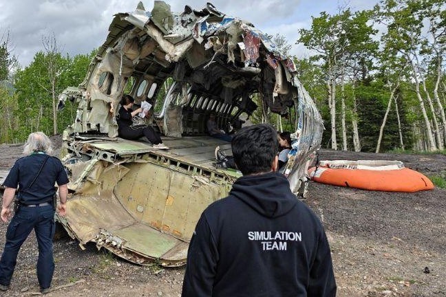 The simulation team looks over the simulated crash site. The crashed DC-9.