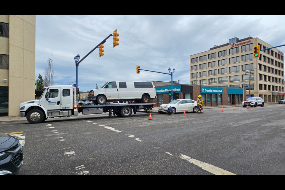 A tow truck crew removes a vehicle involved in a collision at Third Avenue and Victoria Street on Friday, June 11, 2025. 