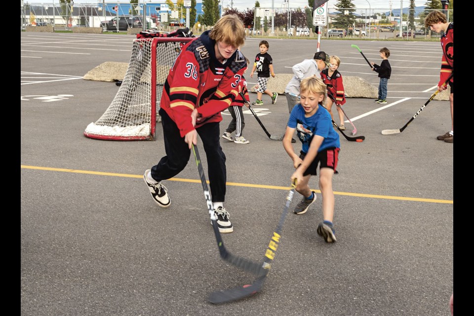Cougar player Leith Hunter, 17, is challenged for the puck by Linden Kirby, 10, as fans got to know the 2024 team at a kickoff barbecue at the CN Centre Wednesday, Sept. 18, 2024 in Prince George, B.C.