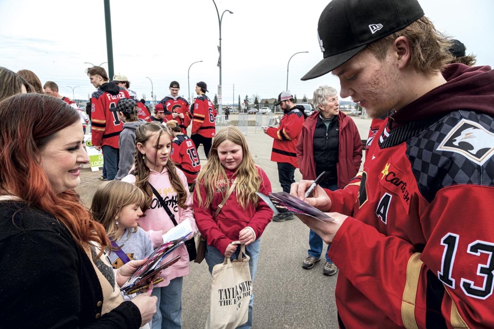 Cougars forward Koehm Ziemmer signs photos for Simone Waller and and daughters Kaylee, 17 (behind mom), Emily, 7, Eva, 11, and Lily, 9, at the Cougars Playoff Kickoff BBQ at CN Centre Tuesday, March 25, 2025.