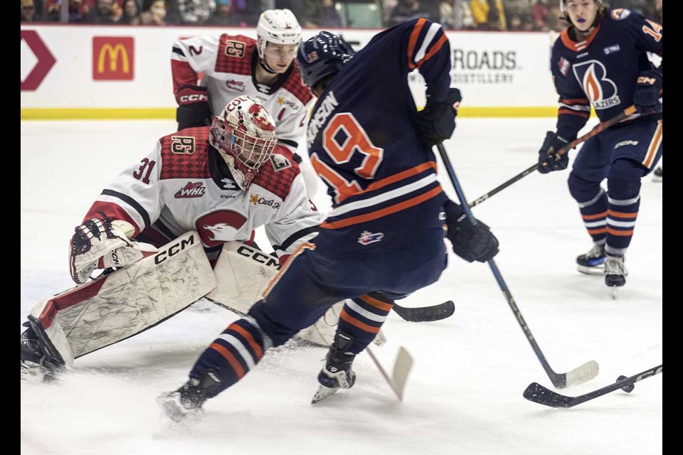 Blazers #19 Andrew Thomson follows his shot in on Cougars goalie #31 Josh Ravensbergen Saturday at CN Centre.