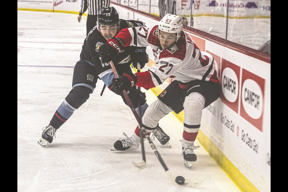 Cougars forward Riley Heidt tries to pass the puck as Winterhawks forward Joel Plante tries to knock it off his stick in Game 2 of their WHL playoff series on Saturday, March 29, 2025 at CN Centre.