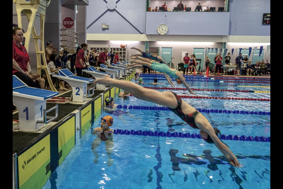 Competitors dive over the swimmers from the last race as they start their 100 metre breaststroke final at the Prince George Barracudas Dental Moose Meet Sunday, April 27, 2025 at the Aquatic Centre.