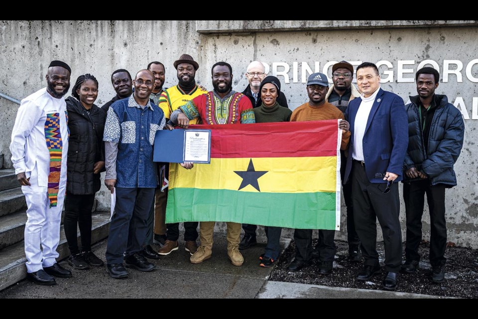 Members of the Ghanaian community hold up the flag and the proclamation Mayor Simon Yu read on the steps of City Hall, declaring Ghana Independence Day in Prince George, on Thursday, March 6, 2025.