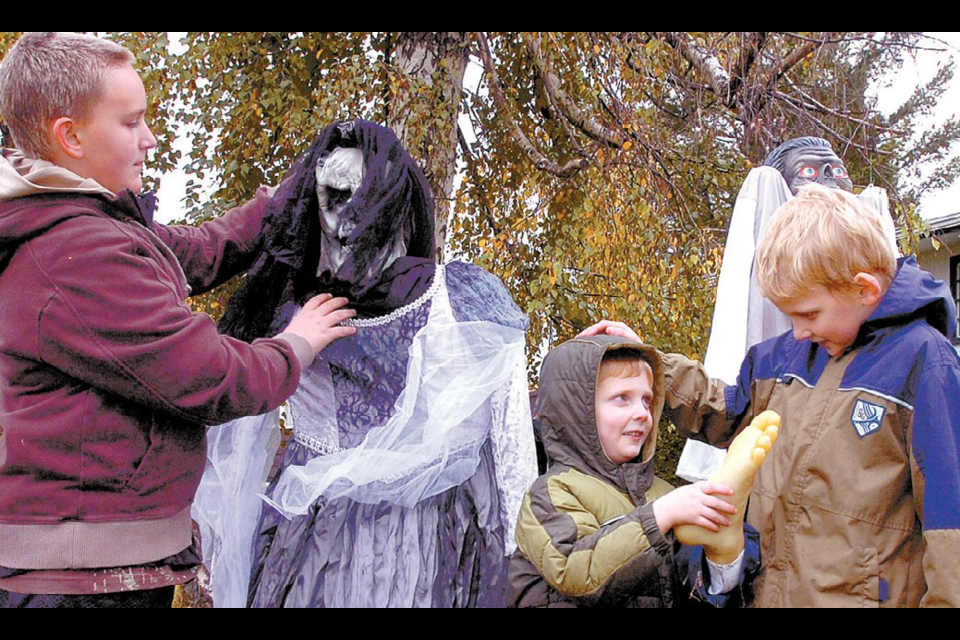 Oct. 17, 2008: It’s fiendish fun as Brennan Lepine, 11, puts together a Halloween yard display while Sam Brodie, 4, and his brother Miles, 7, wonder what to do with a stray foot outside the Lepine home on Willard Place. 
