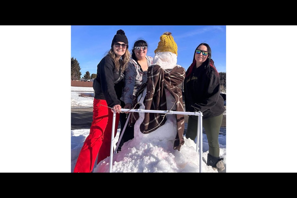 Sarah Bonnar, left, Samantha Dube and Rene Wade brought snow from the Hart to create Agnes the snow lady to bring a little cheer to the Chateau residents in Prince George.