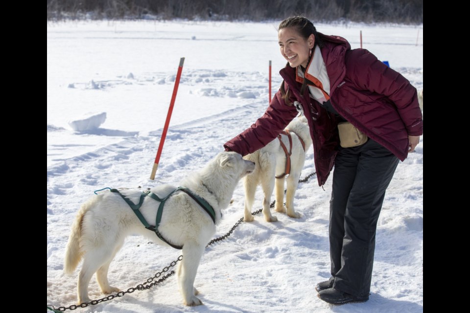 Grace Dove from Prince George pets a husky who is part of a dog sled team during episode 4 of the Amazing Race Canada. 