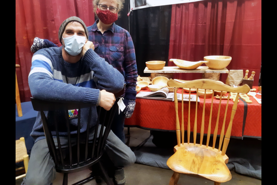 Dave and Shoshanna Godber show off the hand-built birch chairs, bowls and utensils Dave makes for his business, Silver Tree Woodworking. They had a corner booth at the Community Arts Council Studio Fair, which wrapped up Sunday at CN Centre.