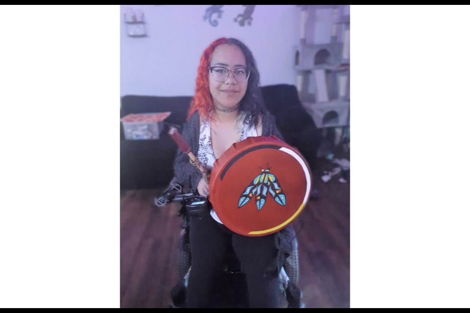 Jenna Wuthrich is a local artist who paints by mouth. Here she is seen with her latest creation, a drum her mom made her that Wuthrich finished by painting it.
