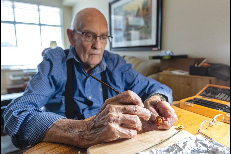 Rae McIntyre, 88, puts the finishing touches on a fisher he will use as part of his latest art project that features his woodcarving skills.