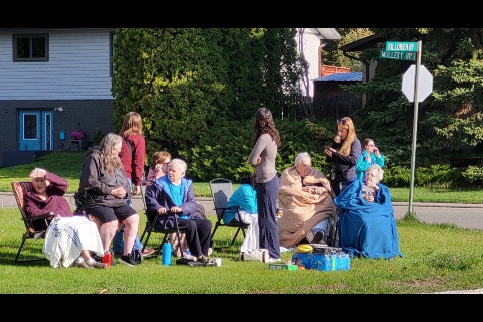 Residents of the Boardwalk Apartments gather on a neighbour's lawn after being evacuated when a fire started at about 5:40 a.m. on Thursday, May 22, 2025.