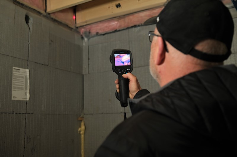 Certified energy advisor Rod Croome uses a monitor to test a home's energy efficiency.