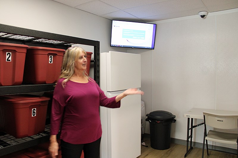 Supervisor Sue Nelson shows the bins where clients are able to keep their things. 