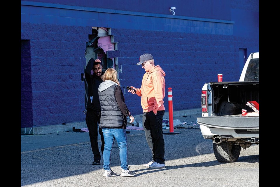 Prince George Walmart store manager Evan Raugust (right), discusses their plan of action with assistant managers Sehajpreet Singh and Margaret Tapanila standing by a hole in the front wall of the store. The store will remain closed today as they await evaluation by a structural engineer to determine how safe the building is after being struck by a Ram pickup struck shortly after 2 a.m. Friday.