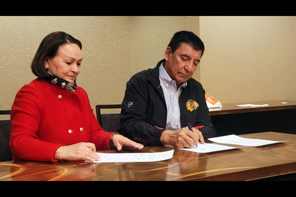 Ulkatcho First Nation Chief Lynda Price, left, signs an economic development agreement with McLeod Lake Indian Band Chief Harley Chingee to create a business partnership between the two nations.