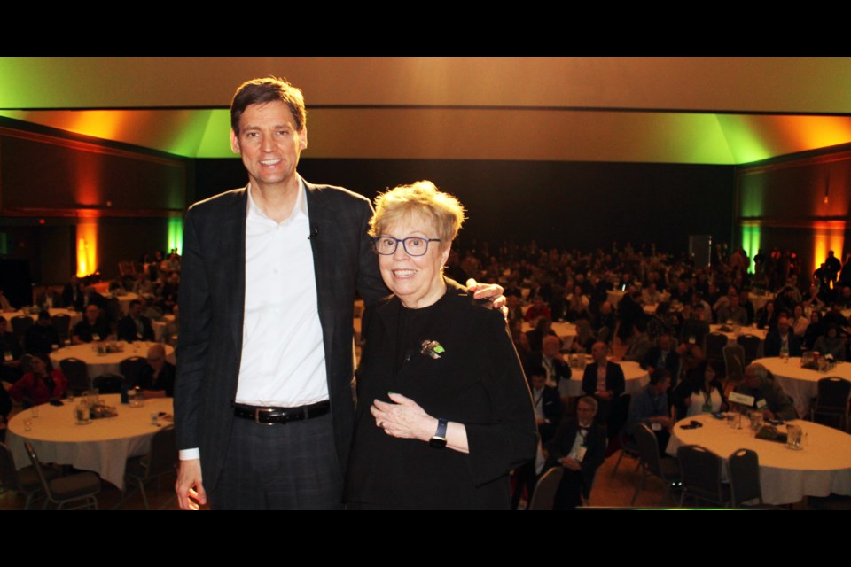 Premier David Eby and BC Council of Forest Industries president and CEO Linda Coady pose in front of a large group of delegates after their discussion on the stage which wrapped up the two-day BC Council of Forest Industries convention at the Prince George Civic and Convention Centre.