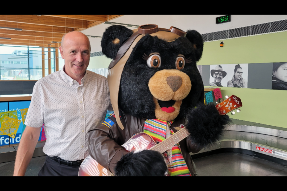 Prince George Airport mascot Amelia Bearhart jams on the guitar with Gordon Duke, CEO of the Prince George Airport Authority during Monday's media announcement of the return of direct flights from Prince George to Mexico.