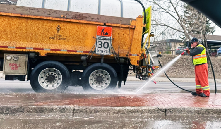 A city employee washes down a Fifth Avenue boulevard near the Fifth Avenue intersection. City crews are now in full swing with street-sweeping operations.