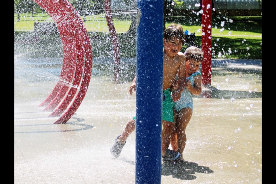 Valentino Paez, 5, and his two-year-old sister Domenica, take advantage of the sunshine and 30 C conditions Wednesday afternoon to cool off under the jets at Roteract Waterspray Park at Lheidli T'enneh Memorial Park. The kids moved to Prince George a month ago with their parents from Chile.