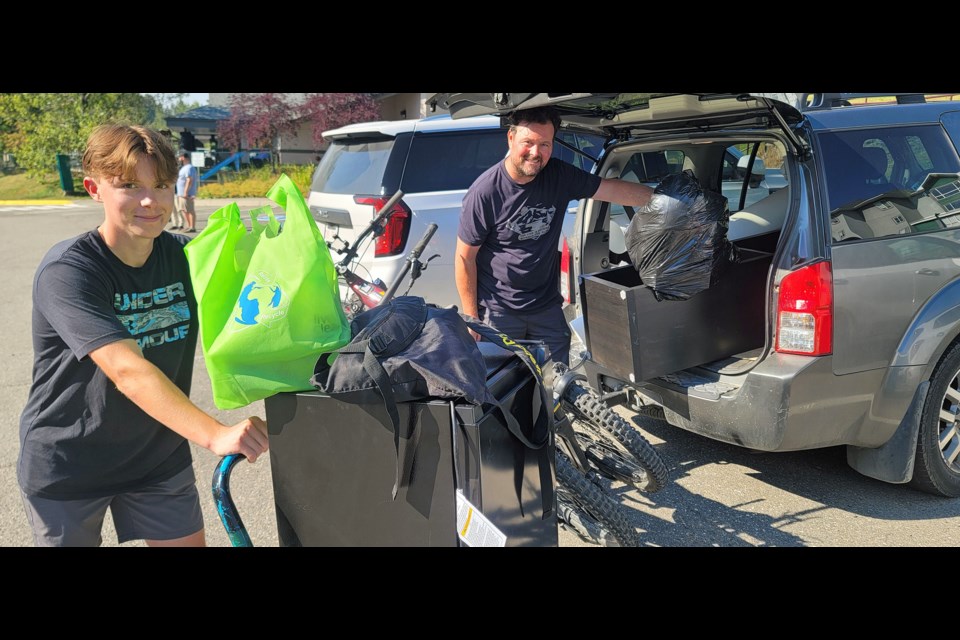 Joel Burnham, left, a second-year UNBC civil engineering student from White Rock, unloads his possessions with the help of his father Jason in the parking lot of the student residence on Thursday, Aug. 28, 2025. Classes start next Wednesday.
