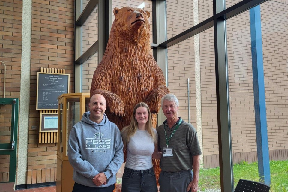 The Willow River 8 Memorial Bursary Fund's first recipient is Emily Parker, a Grade 12 Prince George Secondary School graduate, who is seen with principal Randy Halpape, left, and Class of '74 Reunion Committee member Gerry Van Caeseele. The trio is standing in front of Willow the bear in the PGSS foyer. Willow is a symbol to honour the eight students lost in a tragic canoeing accident on the Willow River on May 10, 1974.