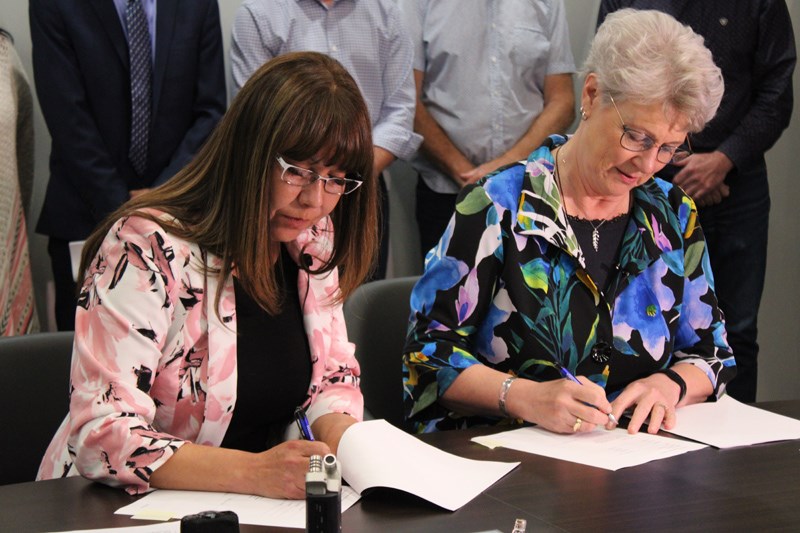 Chief Dolleen Logan and Minister Katrine Conroy sign the agreement. 