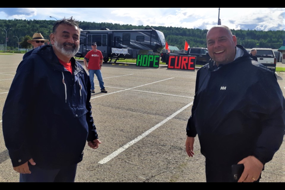 Cristian Silva, left, and Todd Doherty are all smiles Saturday afternoon after they completed a 24-hour walk around the CN Centre parking lot in the virtual Relay For Life. The annual event raised $73, 509 for the Canadian Cancer Society. 