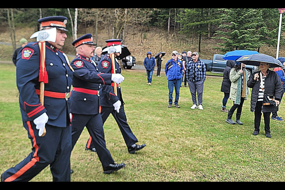 Prince George firefighters hold up their ceremonial axes as they parade at the National Day of Mourning ceremony at the base of Connaught Hill on Monday, April 28, 2025.