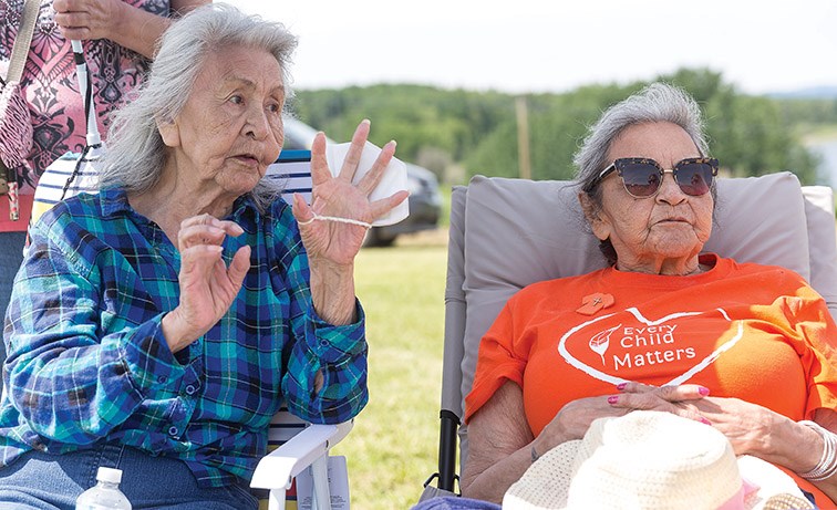 Citizen Photo by James Doyle/Local Journalism Initiative. Residential school survivors Rosie Sam, left, and Zephiria Joseph, right, share a story about their time at the Lejac Residential School on Sunday afternoon during the final day of the Wiping of the Tears Healing Ceremony that was held on the site of the former Lejac Residential School.