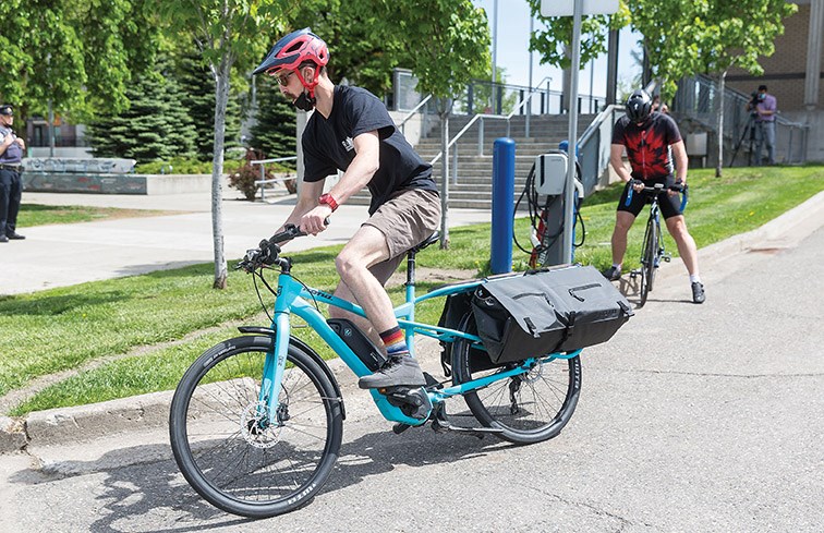 Citizen Photo by James Doyle/Local Journalism Initiative. Jacob Mullen leaves the city hall parking lot on his e-bike while participating in the Go By Bike Man vs Machine Challenge on Saturday afternoon.