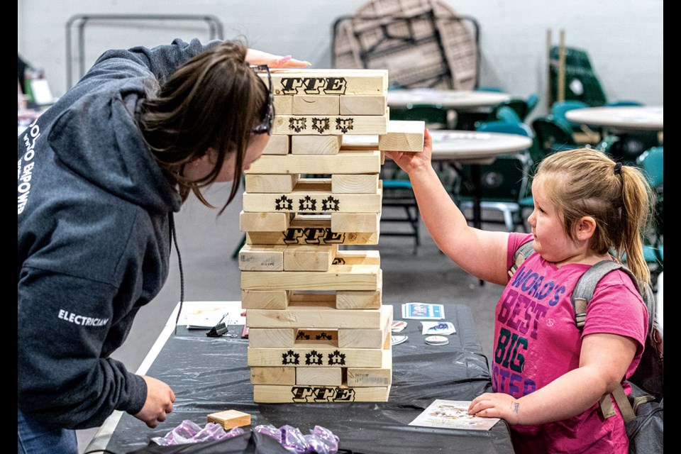 Kaylee Bolin, 6, uses a steady hand to draw a 2x4 from a giant Jenga game while Kendra Shiels, co-founder of Tools To Empower (TTE),  makes sure the tower stays safely in place  at the 44th Annual Canadian Home Builders’ Northern BC Home & Garden Show held in the Kin Centres Friday through Sunday. TTE, part of the Trades Expo, is a non-profit organization started in BC by three tradeswomen who work to introduce and develop skills and different trades to unrepresented groups, women and at-risk youth, showcasing skills and opportunities in trades. The show featured gardening, home renovation and lifestyle choices as well as opportunities to access different trades, training and skills.