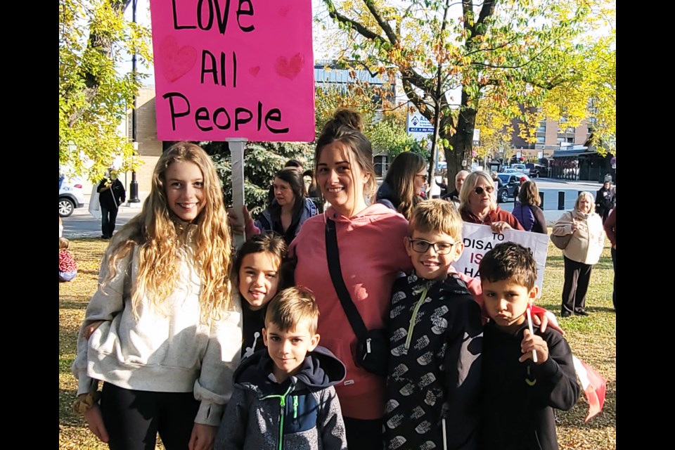 From left, Brielle Jarvis, Caia Wood, Easton Santos, Jaime Moore, Linden Jarvis and Lincoln Wood gather for a group photo at the 1 Million March 4 Children protest Wednesday at city hall.