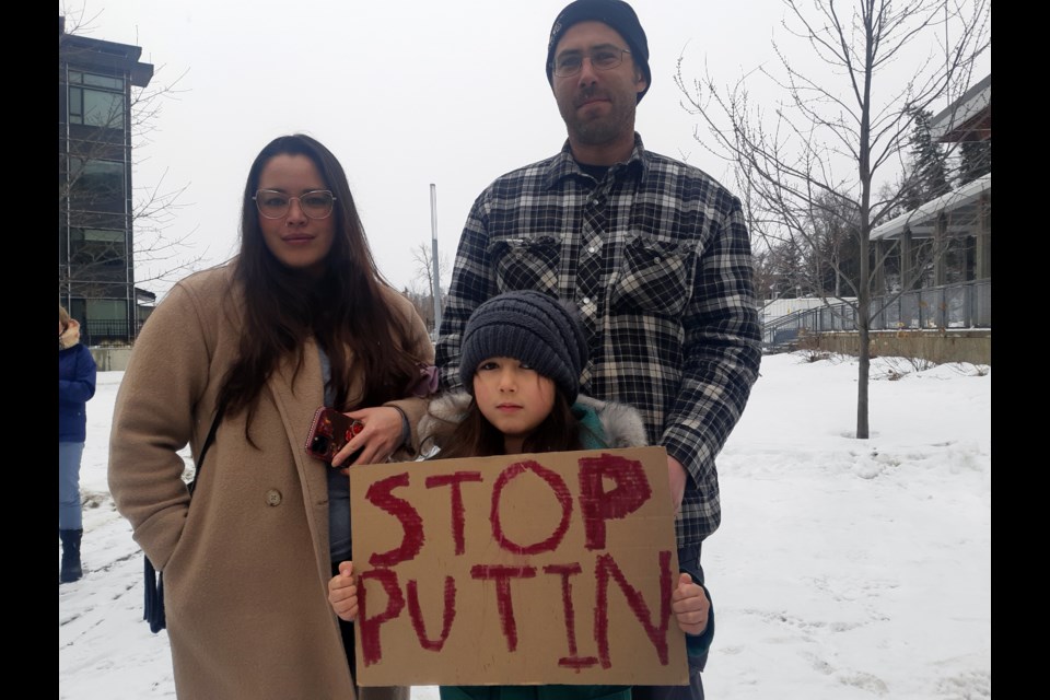 Kaitlyn Studney show her solution to the war in Ukraine, flanked by her parents, Elaina Woo and Chris Studney at Sunday's protest at Prince George city hall. 