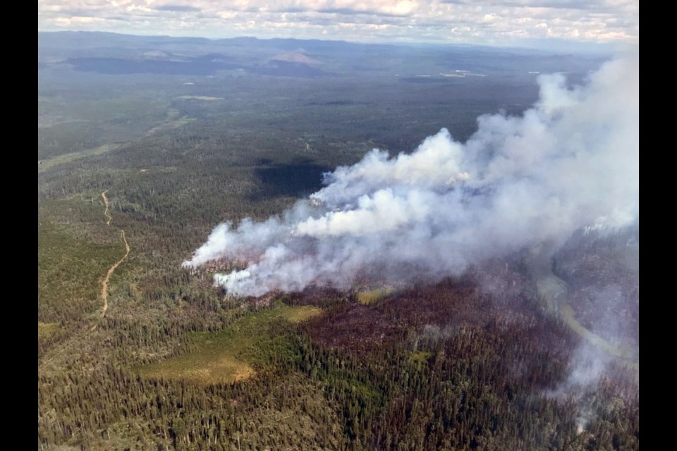 Smoke billows from trees being consumed by the Cutoff Creek wildfire southwest of Vanderhoof.